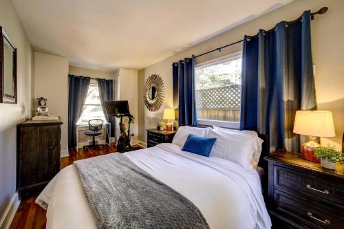 a bedroom with a large bed with blue curtains at Pet Friendly and Historic Prescott Home with Fire Pit! in Prescott