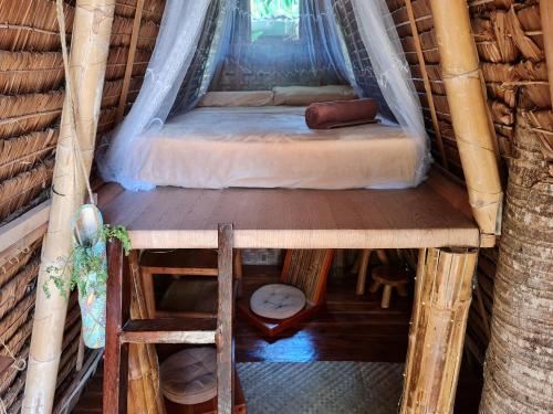 a bed in a room in a tree house at Wonderland in Siquijor