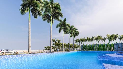 ein großer Pool mit Palmen im Hintergrund in der Unterkunft Seabird Hotel Thien Cam in Provinz Hà Tĩnh