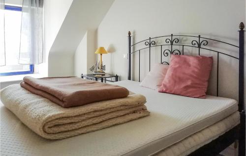 a bedroom with a large bed with a pink pillow at Stunning Home In Cadouarn With 2 Bedrooms, Wifi And Outdoor Swimming Pool in Séné