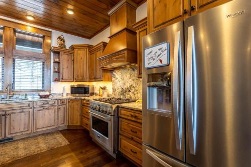 a kitchen with a stainless steel refrigerator and wooden cabinets at Cardinal Perch in Beech Mountain