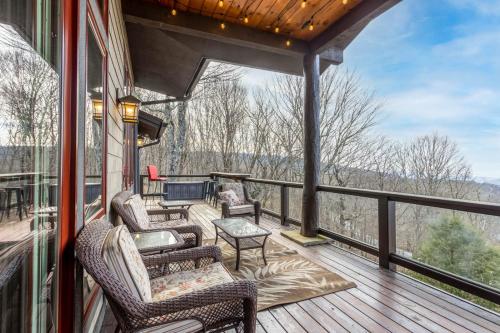 a porch with chairs and a table on a deck at Cardinal Perch in Beech Mountain