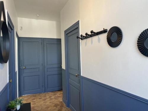 a hallway with a blue door and a mirror at Maison rénovée avec jardin clos, proche du centre historique, idéale pour famille ou télétravail - FR-1-489-439 in Moulins