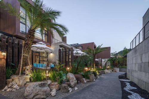 a walkway in front of a building with palm trees at Deer Chaser Hotel in Yuchi
