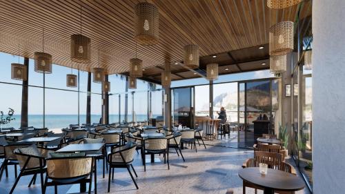 een restaurant met tafels en stoelen en uitzicht op de oceaan bij Seabird Hotel Thien Cam in Ha Tinh