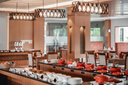 a restaurant with tables and chairs and red dishes at Soaltee Westend Resort Chitwan in Chitwan