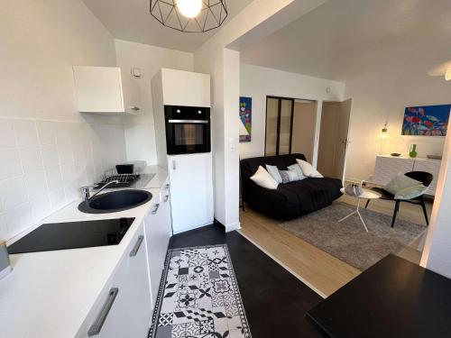 une cuisine et un salon avec un canapé dans l'établissement Appartement rénové à Bénodet, plage à 100m, terrasse, parking, proche thalasso et restaurants - FR-1-481-136, à Bénodet