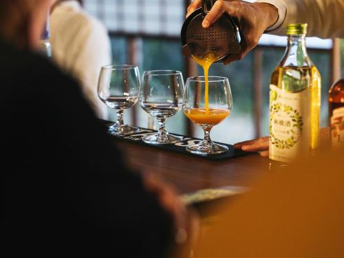 a person pouring wine into wine glasses on a tray at Minamo in Ukiha
