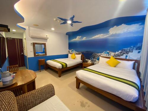 a bedroom with two beds and a blue wall at Kenting Sin Sin Hotel in Kenting