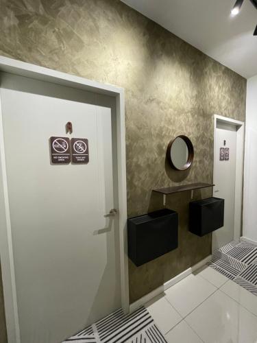 La salle de bains est pourvue d'une porte blanche et d'un miroir. dans l'établissement jugi suite @ Horizon Sepang KLIA, à Sepang