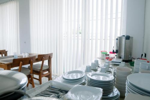 拉布安的住宿－Christika Homestay，上面有盘子和盘子的桌子