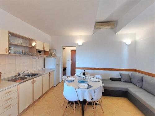 a kitchen and living room with a table and a couch at Apartments Jera- barbecue in Sevid