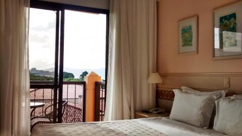 a hotel room with a bed and a balcony at Jurerê Beach Village Studios Para Temporada in Florianópolis