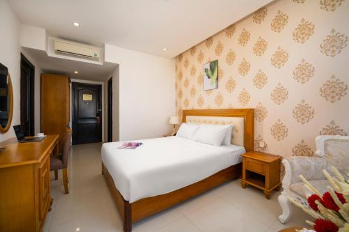 a bedroom with a bed and a desk and a chair at Royal Family Hotel in Da Nang