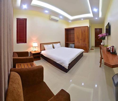 Nam ÐịnhにあるRuby Hotelのベッドルーム1室(ベッド1台付)、リビングルームが備わります。