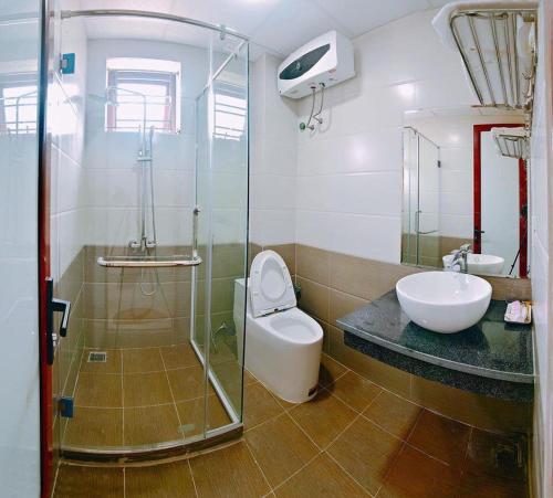 y baño con aseo, lavabo y ducha. en Ruby Hotel, en Nam Ðịnh