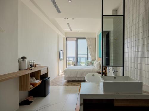 a white bathroom with a bed and a sink at Kenting Sea Wall 130 in Kenting