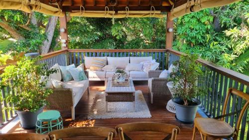a porch with a couch and chairs on a deck at Magnetic Mango Escape in Horseshoe Bay