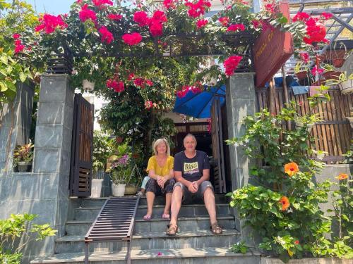a man and a woman sitting on the stairs at Phuoc Dat Riverside Homestay Hoi An in Hoi An
