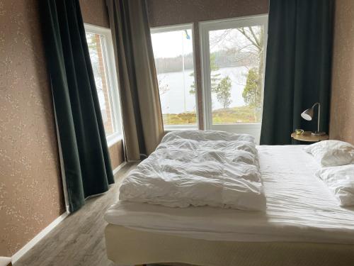 a bed in a room with a large window at Fantastic holiday home with own lake plot by Bolmen, Ljungby in Ljungby