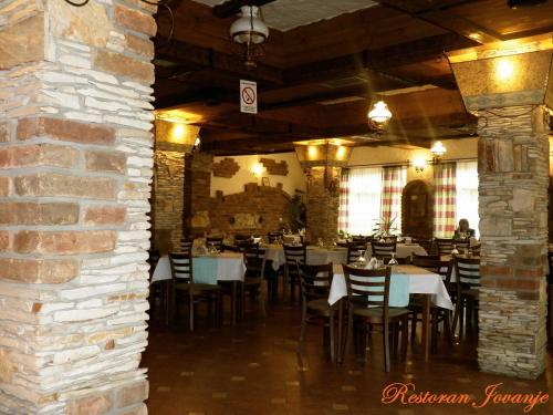 a dining room with tables and chairs and a brick wall at Konak Jovanje in Belgrade
