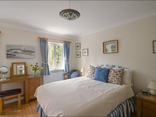 a bedroom with a bed and a desk and a window at Jurassic Sea View in Lyme Regis