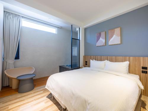a bedroom with a bed and a desk and a window at Kenting Sea Wall 130 in Kenting