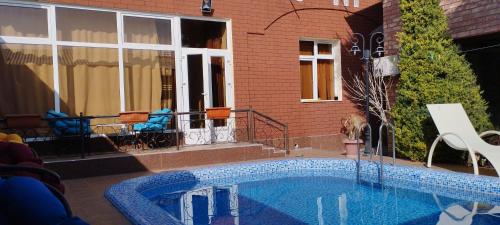 a swimming pool in front of a house at Green House ECO HOTEL in Samarkand