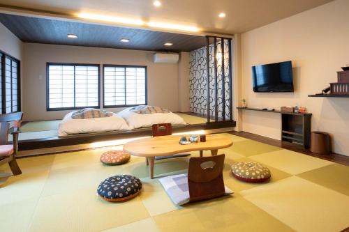 een woonkamer met een bed en een tafel bij Oyado Eitaro in Takayama