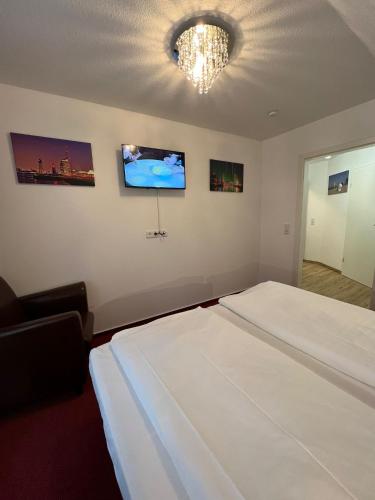 a bedroom with two beds and a chandelier at Hotel Columbus und Glamping in Bremerhaven
