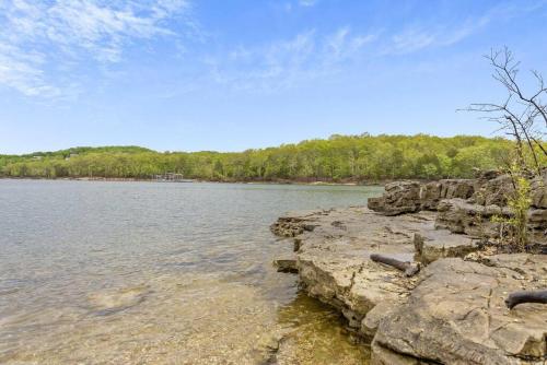 a large body of water with rocks and trees at Cozy Lakeside Getaway - Outdoor Theater - Free Early Check-In- 4min to Silver Dollar City in Branson