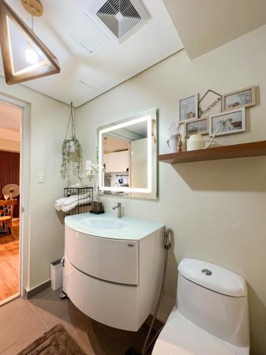a bathroom with a white toilet and a sink at An Oasis in Tagaytay - Serin in Tagaytay