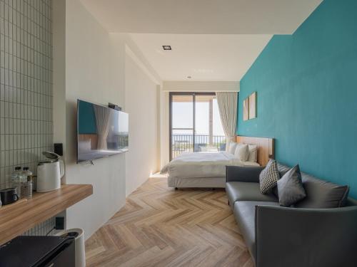 a bedroom with a bed and a couch in a room at Kenting Sea Wall 130 in Kenting