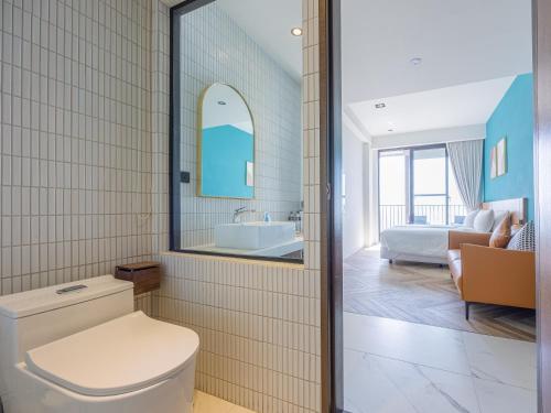a bathroom with a toilet and a bedroom at Kenting Sea Wall 130 in Kenting