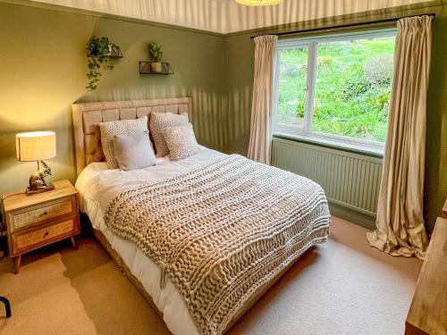 a bedroom with a large bed and a window at Upalong in West Lulworth