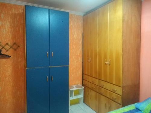 a bedroom with blue and yellow cabinets in a room at Apto Pé na Areia Próx Centro Boqueirao PG in Praia Grande