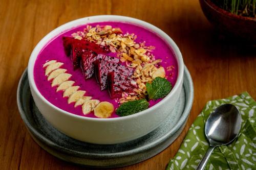 Un tazón de comida con un plato rosa de comida. en Jati Cottage, en Ubud