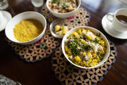 uma mesa com tigelas de comida e uma chávena de café em amã Stays & Trails Asanji Wadi, Alibag em Alibag