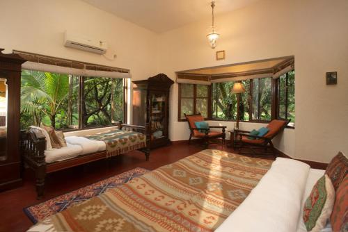 a bedroom with two beds and a table and chairs at amã Stays & Trails Asanji Wadi, Alibag in Alibaug