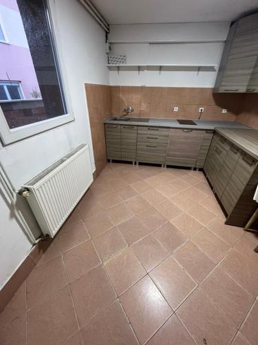 uma cozinha vazia com piso em azulejo e uma janela em 中华楼 - em Belgrado