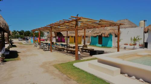 a pavilion with tables and benches and a pool at Casa Frida in Chelem