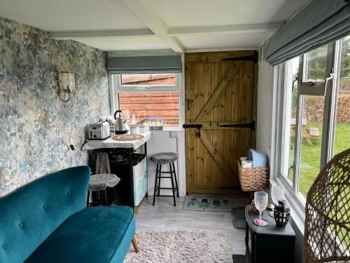 Habitación con cocina con barra y puerta. en Bothy hut en Tring