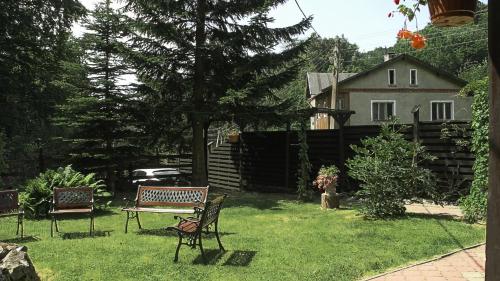 a yard with two benches and a house at Zachęta in Sokolec