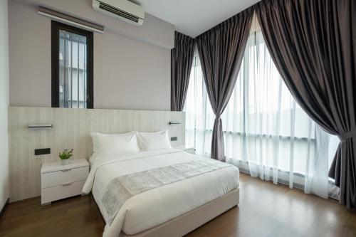 a bedroom with a white bed and large windows at Opus KL Residences by Premium Hospitality in Kuala Lumpur