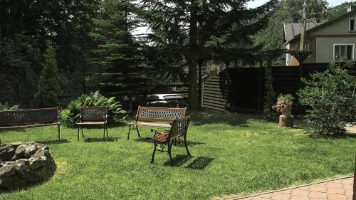 two benches sitting in the grass in a yard at Zachęta in Sokolec