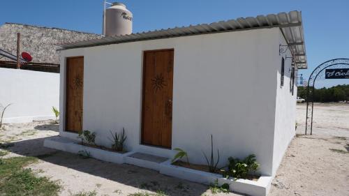 a small white building with a wooden door at Casa Frida in Chelem