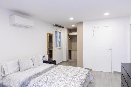 マラガにあるPEDREGALEJO BEACH APARTMENTの白いベッドルーム(ベッド1台、クローゼット付)