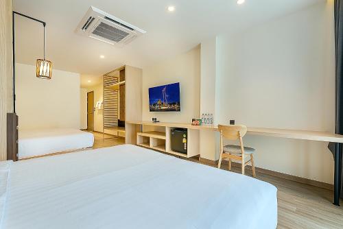 a white bedroom with a bed and a desk at Phra Nakhon Poshtel in Bangkok