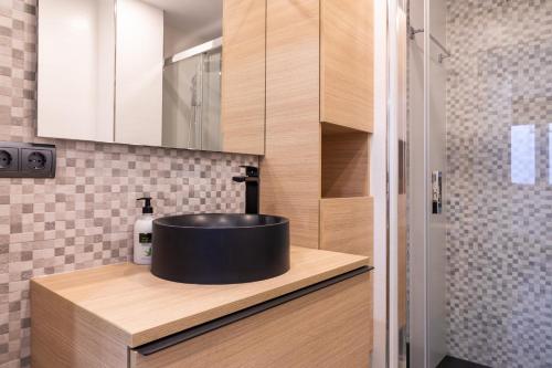 マラガにあるPEDREGALEJO BEACH APARTMENTのバスルーム(木製カウンターの黒い洗面台付)