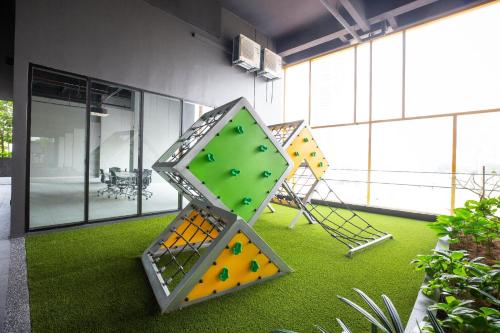 a room with a bunch of play equipment on the grass at Opus KL Residences by Premium Hospitality in Kuala Lumpur